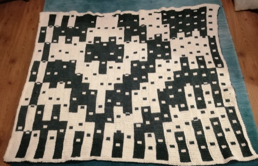 Knitted blanket in two colours, with stripes and dots